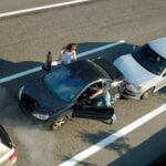A small shunt on the freeway (motorway, autoroute, autobahn) a few seconds after it happened. Steam can be seen coming from under the bonnet of the black car. Motion blur on the passenger fleeing in p A small shunt on the freeway (motorway, autoroute, autobahn) a few seconds after it happened. Steam can be seen coming from under the bonnet of the black car. Motion blur on the passenger fleeing in p