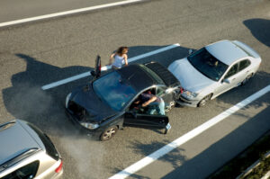 A small shunt on the freeway (motorway, autoroute, autobahn) a few seconds after it happened. Steam can be seen coming from under the bonnet of the black car. Motion blur on the passenger fleeing in panic.