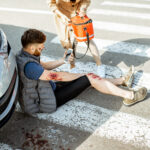 Woman driver with injured man on the road Woman driver with injured man on the road