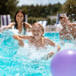 Parents and children laughing while playing ball in swimming pool Parents and children laughing while playing ball in swimming pool
