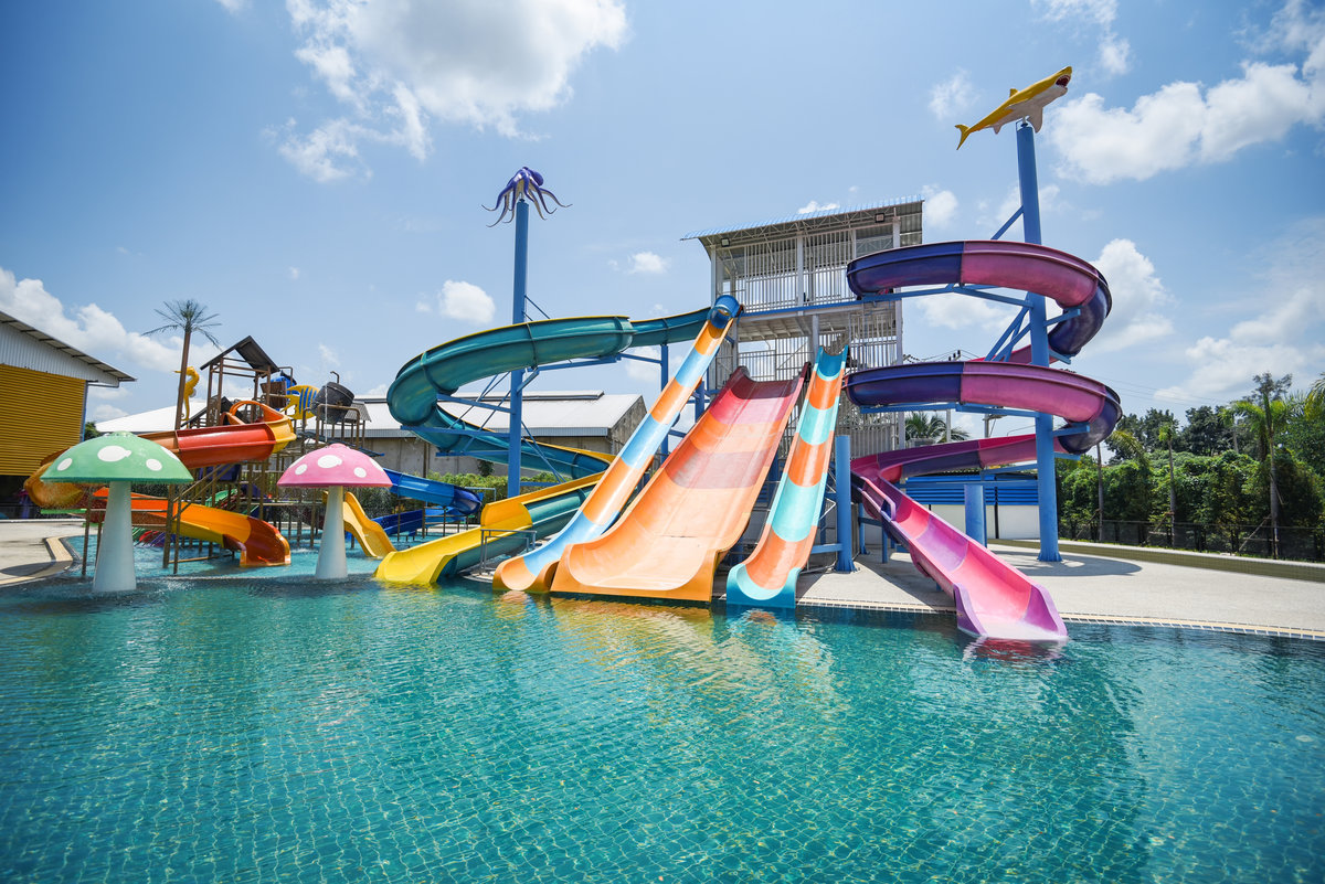 water park slide with swimming pool at amusement park - colored plastic water slides with pool in outdoor aqua park